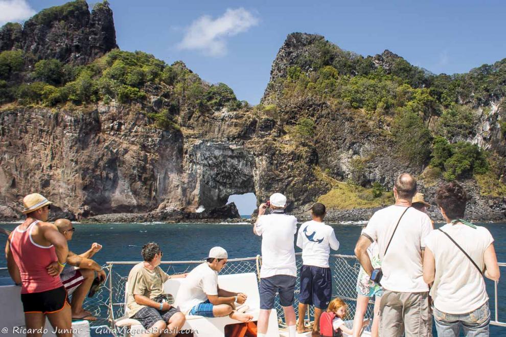 Imagem de turistas registrando as belezas de Noronha.